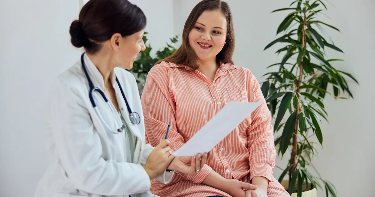 Provider measuring a patient's waist during a medical weight loss consultation at iCRYO Grosse Pointe